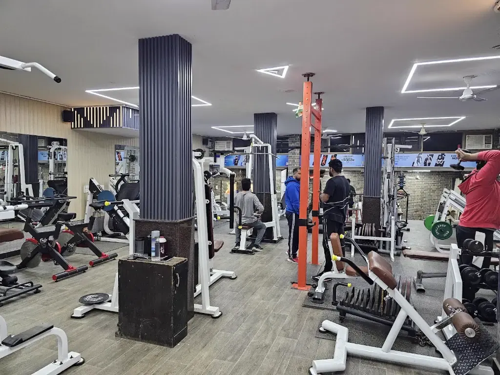 The main training floor at Kiyan's Fitness Point, lined with machines, a free-weight rack area and cushioned flooring
